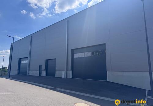 Modern facade featuring large sectional doors (H 3.5m to 4.5m) and heavy vehicle access.